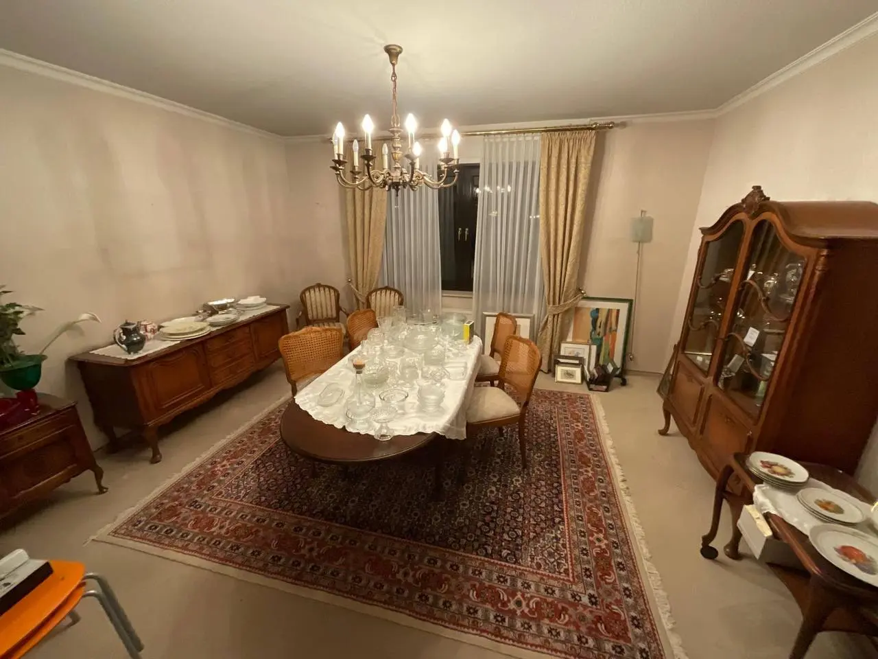Esszimmer mit Kronleuchter und Vitrine in einer Wohnung vor der Räumung