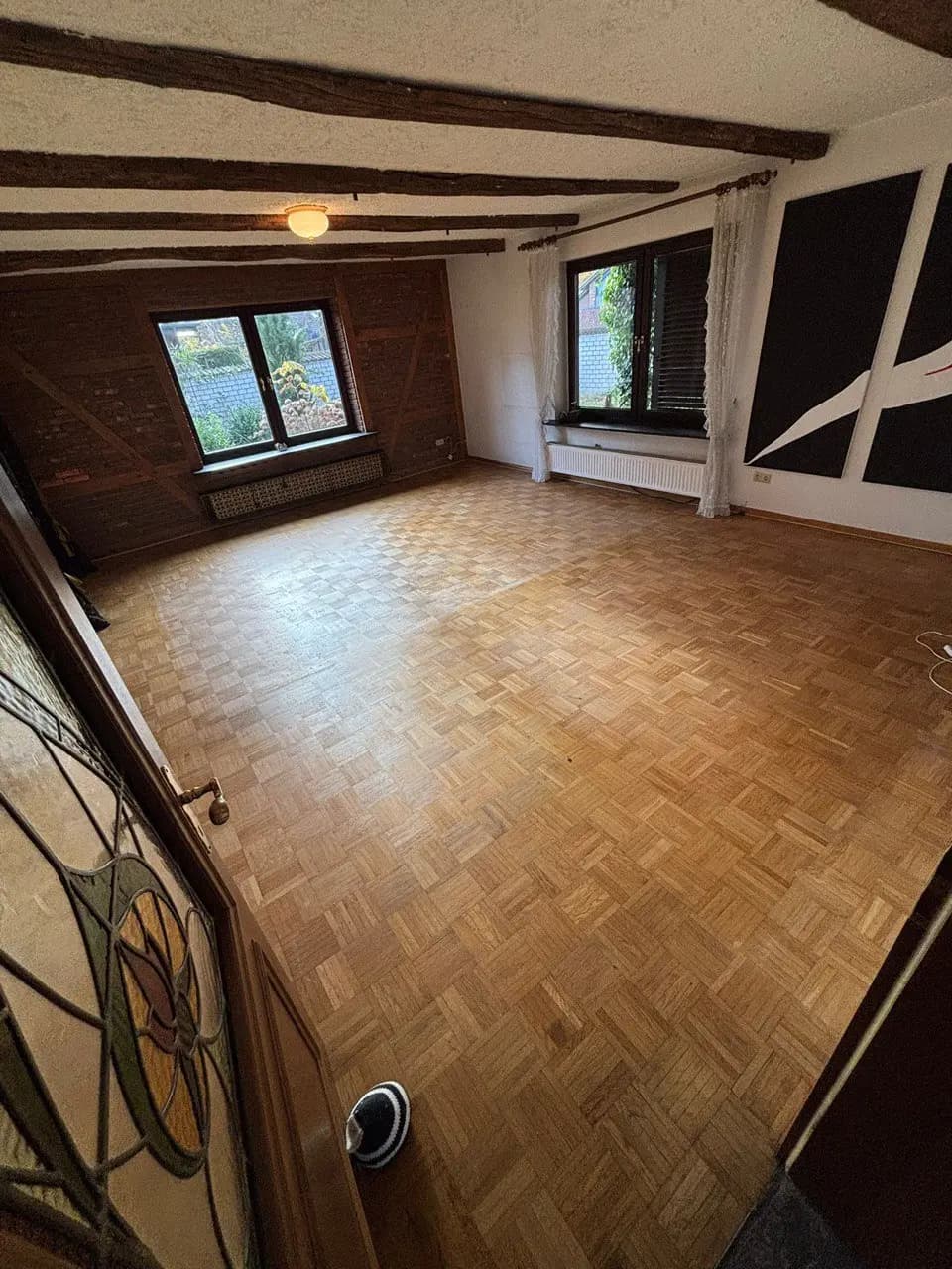 Leerer Raum mit Fachwerkwand und Holzboden nach der Räumung