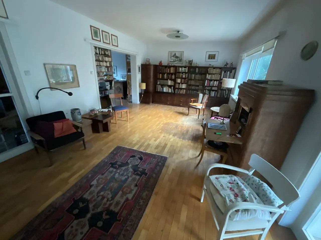 Wohnzimmer mit Bücherregal, Sesseln und Teppich vor der Räumung