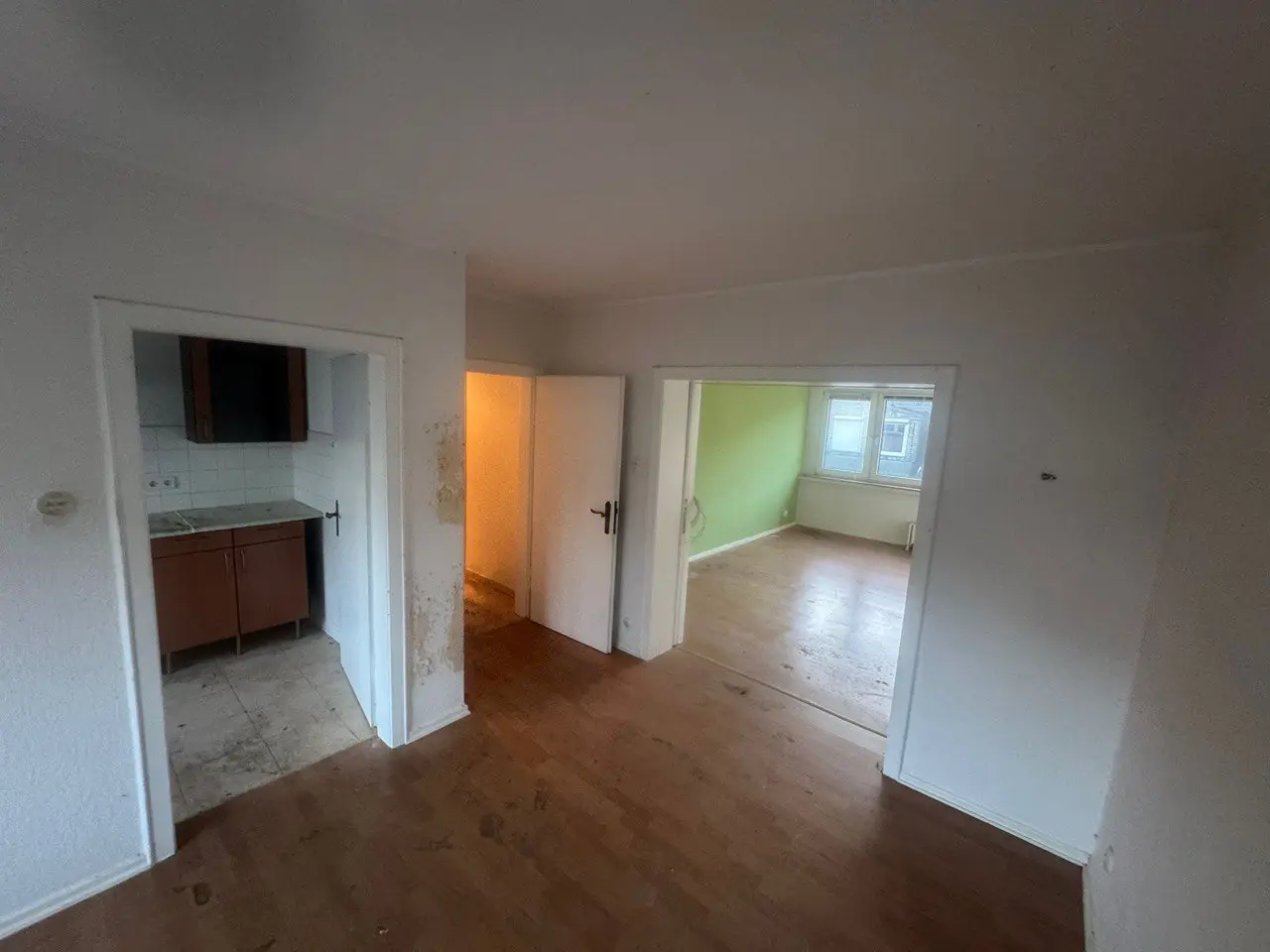 Leere Wohnung mit Blick durch den Flur in die Küche